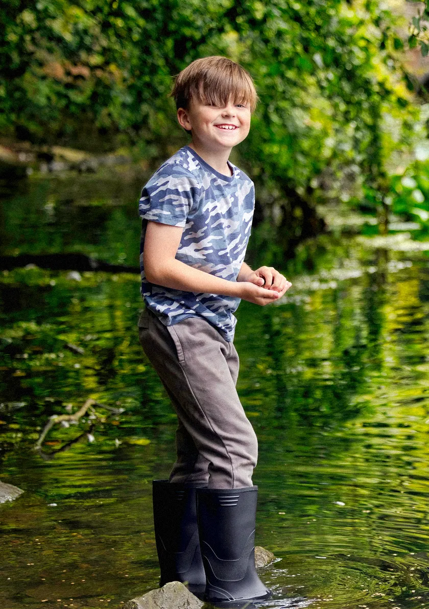 young girl sitting on the sofa with her headphones using mobile device